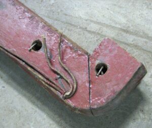 Reclaimed brown wooden banister handrail with spindle holes, shown in a close-up view of one end and the attached holes along the rail.