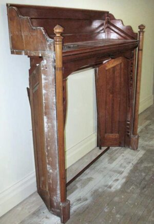 Traditional built-in mantel with geometric side details, shown in a dark wood tone from the front at an angle.