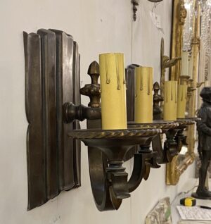 Pair of restored traditional bronze wall sconces with two arms and candle-style holders in an antique bronze finish.