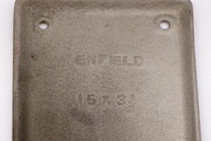 Close-up of a steel door push plate with two screw holes and faint Russwin Enfield embossing, shown in a brushed steel finish.
