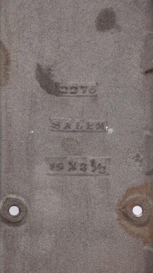 Close-up of the back of a cast iron door push plate with molded Salem markings and two mounting holes visible.