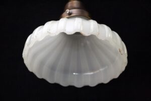 Fluted white glass pendant light shade shown from below with a scalloped rim and a metal fitter at the top.