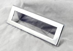 Stainless steel finished mail slot cover with a rectangular opening shown at an angle.
