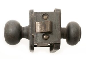 Close-up of an Art Deco lock set with two rounded doorknobs and an attached lock box, shown in antique bronze finish.