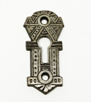 Decorative cast iron key escutcheon plate with an Aesthetic-style geometric pattern and three keyhole openings.