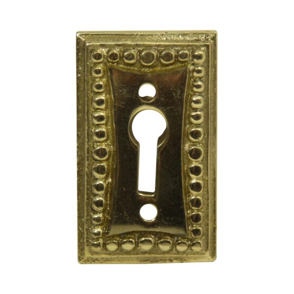 Rectangular brass keyhole cover with bubbled edge detailing and a keyhole opening.