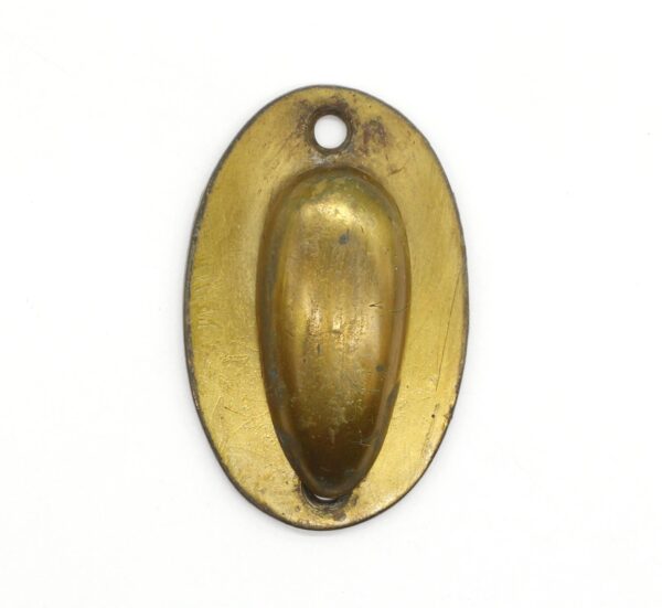 Vintage brass oval keyhole cover with a raised center draft plate and a mounting hole at the top.