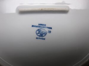 Underside of a ceramic vegetable bowl with a blue maker’s mark reading Lorenz Hutschen Reuther, Germany, and style 30 stamped on the base.