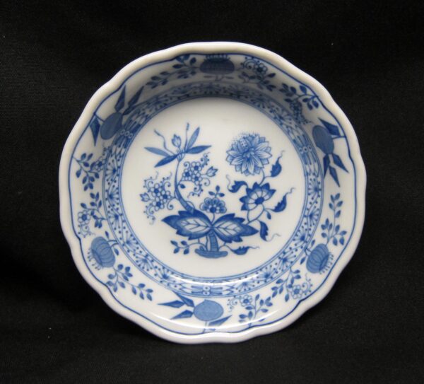 Blue and white ceramic fruit dessert bowl with a scalloped rim and floral pattern inside and around the edge.
