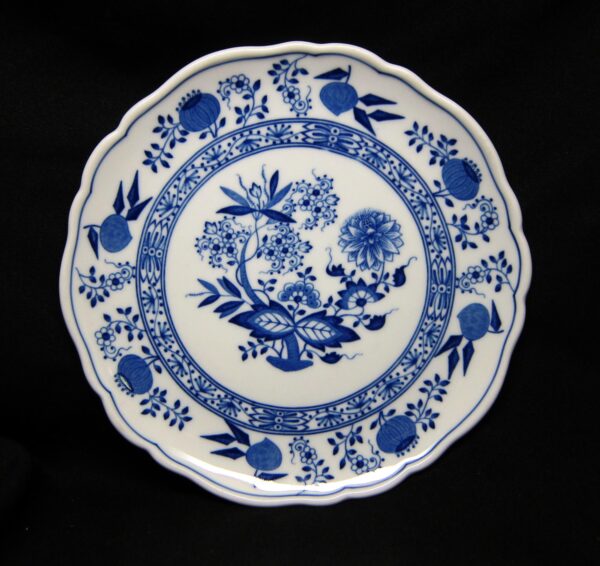 Blue and white ceramic salad plate with a scalloped rim and blue floral Blue Onion pattern.