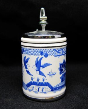 Blue and white ceramic shaker with a metal top and Oriental design featuring birds and landscape motifs.