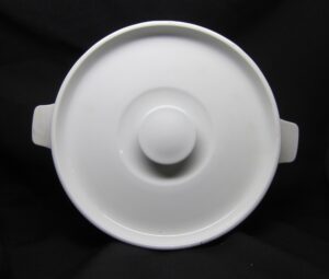 White ceramic soup pot lid with a central knob and side handles, shown from above.