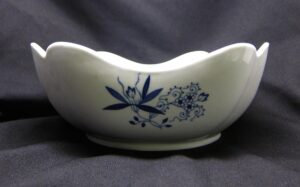Ceramic vegetable bowl with a blue floral pattern and scalloped rim.