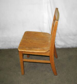 Medium toned wooden chair with a simple ladder back design shown in side view.