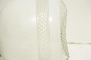Close-up of a semi flush mount light with a white and clear glass shade.