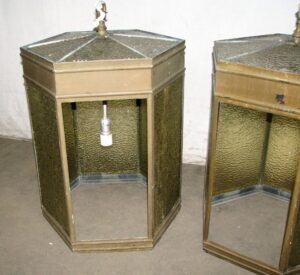 Hexagonal pendant lantern with amber glass panels and a brass frame, shown with several glass panels missing and a hanging socket visible inside.