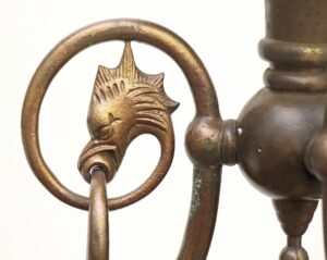 Close-up of a brass pendant ceiling lantern with a griffin head detail and circular ring support.