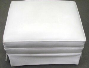 White vinyl ottoman shown from above, with a square cushioned top and fitted skirt.