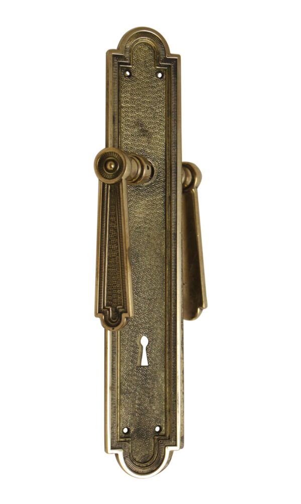 French-style bronze door lever handle and keyhole plate with an ornate long backplate and keyhole opening, shown in a vertical close-up view.
