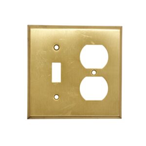 Brushed brass wall plate cover with one toggle switch opening, one duplex outlet opening, and two screw holes, shown with surface wear from prior use.