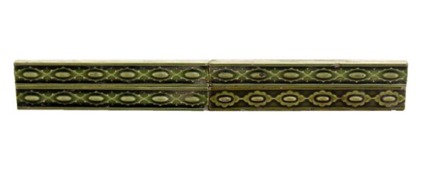 Set of green ceramic liner wall tiles shown in a long horizontal row with a decorative repeating pattern and visible age-related chips and wear.