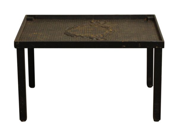Cast iron coffee table with a beaded top and decorative wreath motif on the surface, shown with four straight legs.
