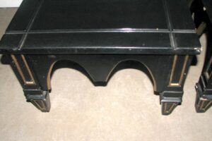 Black Gothic side table with gold details shown from the front, featuring an arched cutout apron and square top.