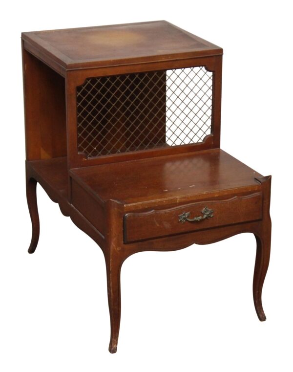 Vintage side table with a single drawer, open shelf, and lattice-front panel, shown in dark wood tone.