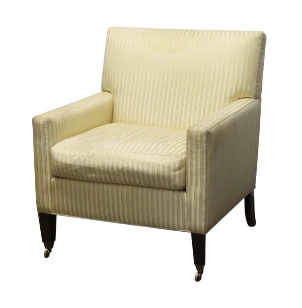 Tan striped upholstered chair with a tall back, padded arms, front casters, and a visible stain at the top of the back cushion.