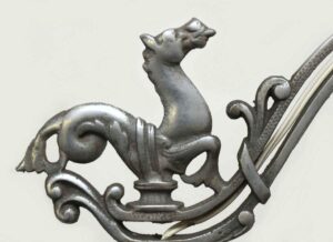 Close-up of a traditional floor lamp showing the horse motif and ornate curved metalwork at the top.