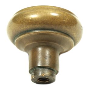 Close-up of an antique bronze Gothic door knob with a rounded top and threaded stem.