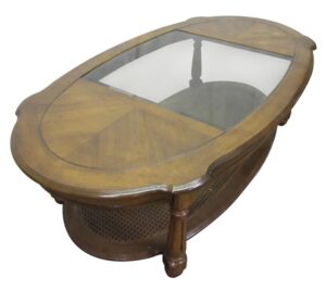Oval oak coffee table with a center glass top, shown at an angle with four post legs and a lower caned shelf.