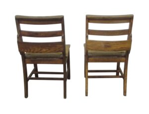 Pair of antique schoolhouse chairs shown from the back, with square wooden frames, three-pane back supports, and woven seats in a light wood tone.
