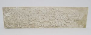 A light yellow ceramic decorative border tile with a crackled raised surface shown in a front view.