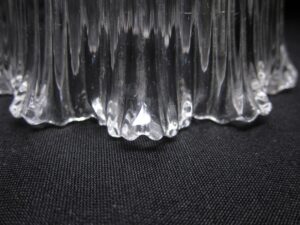 Close-up of the clear prism glass pendant light, showing the scalloped lower edge and vertical ribbed pattern.