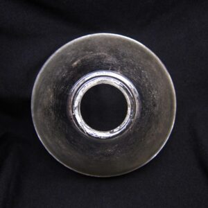 Close-up of a clear glass pendant light fitter with a polished nickel wired opening centered in the shade.