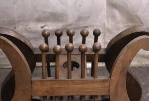 Close-up of a carved wooden music or book stand with rounded side supports and vertical finials across the top.