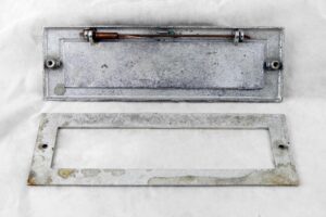 Stainless steel mail slot with a spring-loaded flap and matching interior plate shown separately.