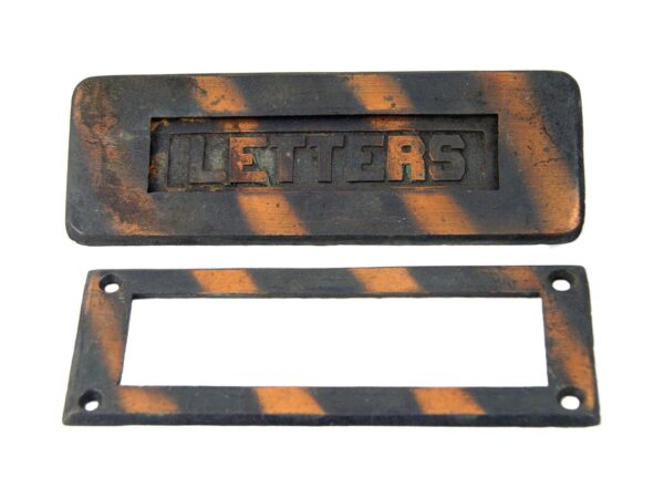 Vintage cast iron door mail slot set with a rectangular opening plate and matching lettered faceplate, shown in a black and copper finish.