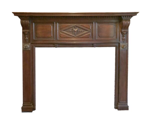 Oversize Rococo fireplace mantel with carved details and a central decorative panel, shown front on in a dark wood tone.