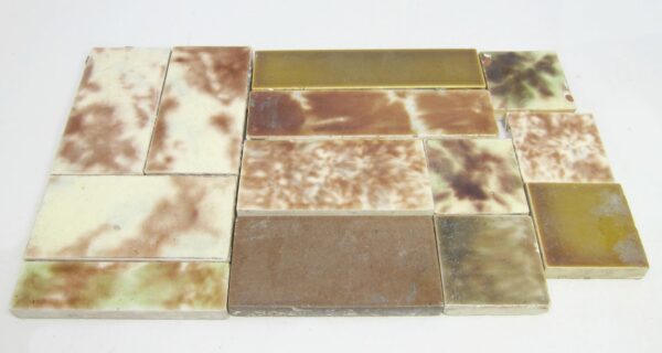 Set of 11 assorted ceramic tiles with mixed brown tones, shown in a grouped arrangement with visible age-related imperfections and minor chips.
