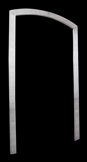 White carved marble arched molding with floral ornament on the vertical sides and curved top, shown as a tall door surround against a plain background.