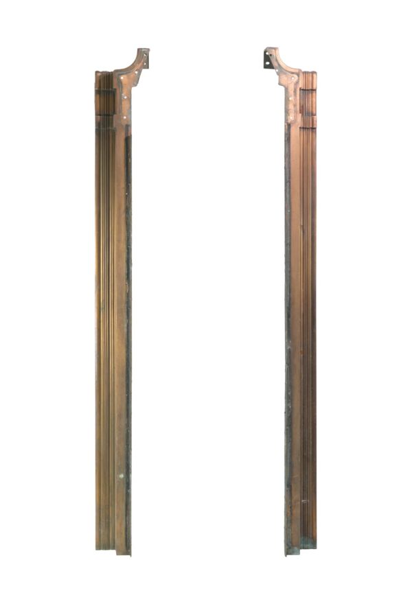 Pair of bronze door pilasters shown side by side, with tall Art Nouveau detailing and mounting brackets at the top.