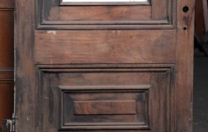 Single slanted arch door with two wood panels in a dark wood tone, shown close up with the glass missing.