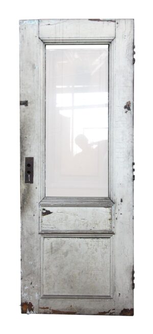 Antique wooden entry door with one narrow beveled glass panel and two wood panels, shown in a distressed white finish.