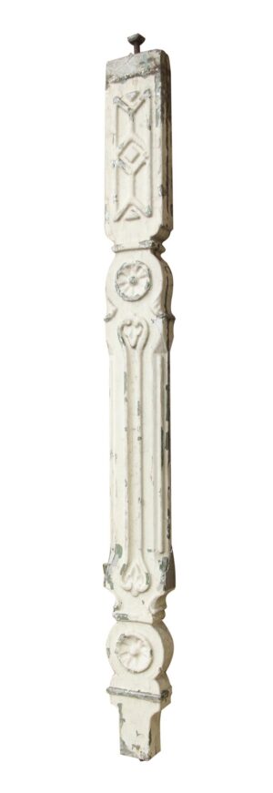 A white Victorian cast iron staircase baluster with ornate raised detailing and chipped paint.