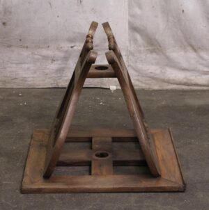 Carved wooden music or book stand shown folded open in a triangular shape with a medium wood tone.