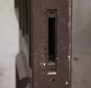 Close-up of a brown pine pocket door edge with the latch mortise visible.
