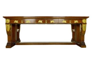 French Empire mahogany desk with gilt bronze ornament and three drawers, shown front view.