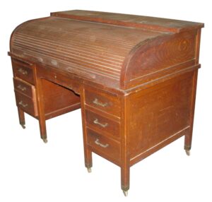 Antique roll top wooden desk with a curved tambour front, multiple drawers, and casters, shown in a medium wood tone.